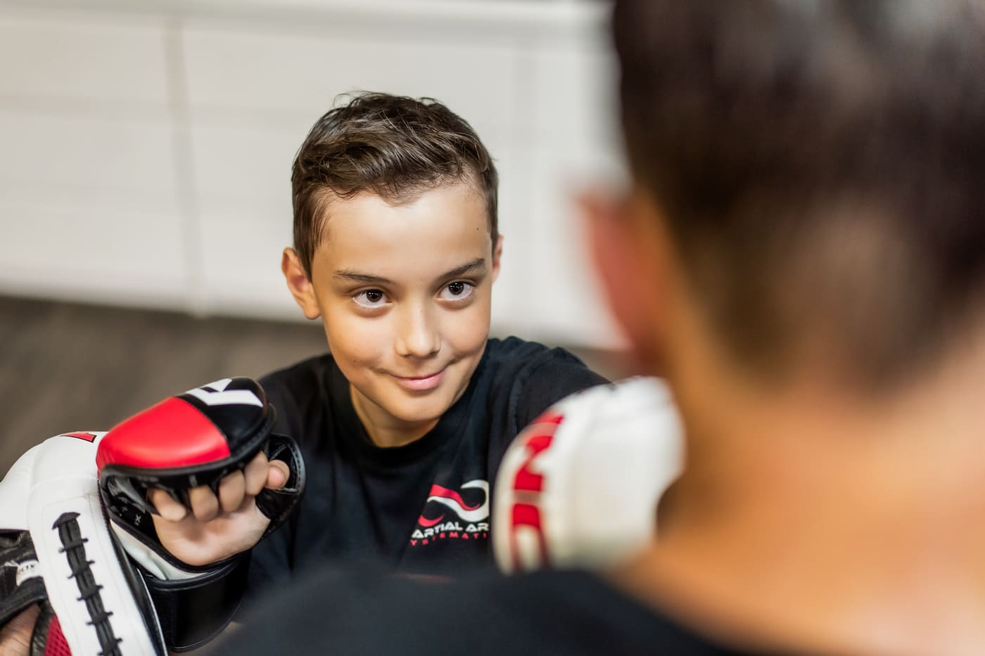 Kind mit Boxhandschuhen beim Kampfsporttraining
