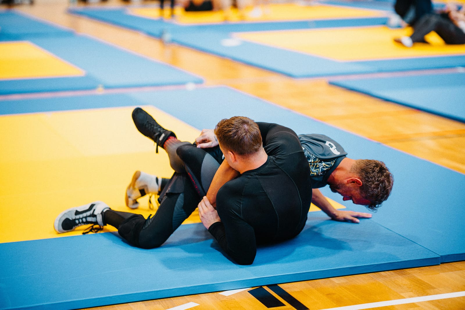 Kimura-Ansatz aus der Guard-Position beim Brazilian Jiu-Jitsu (BJJ) auf der Matte in der Akademie für Selbstverteidigung, Kampfkünste und Kampfsport in Graz.
