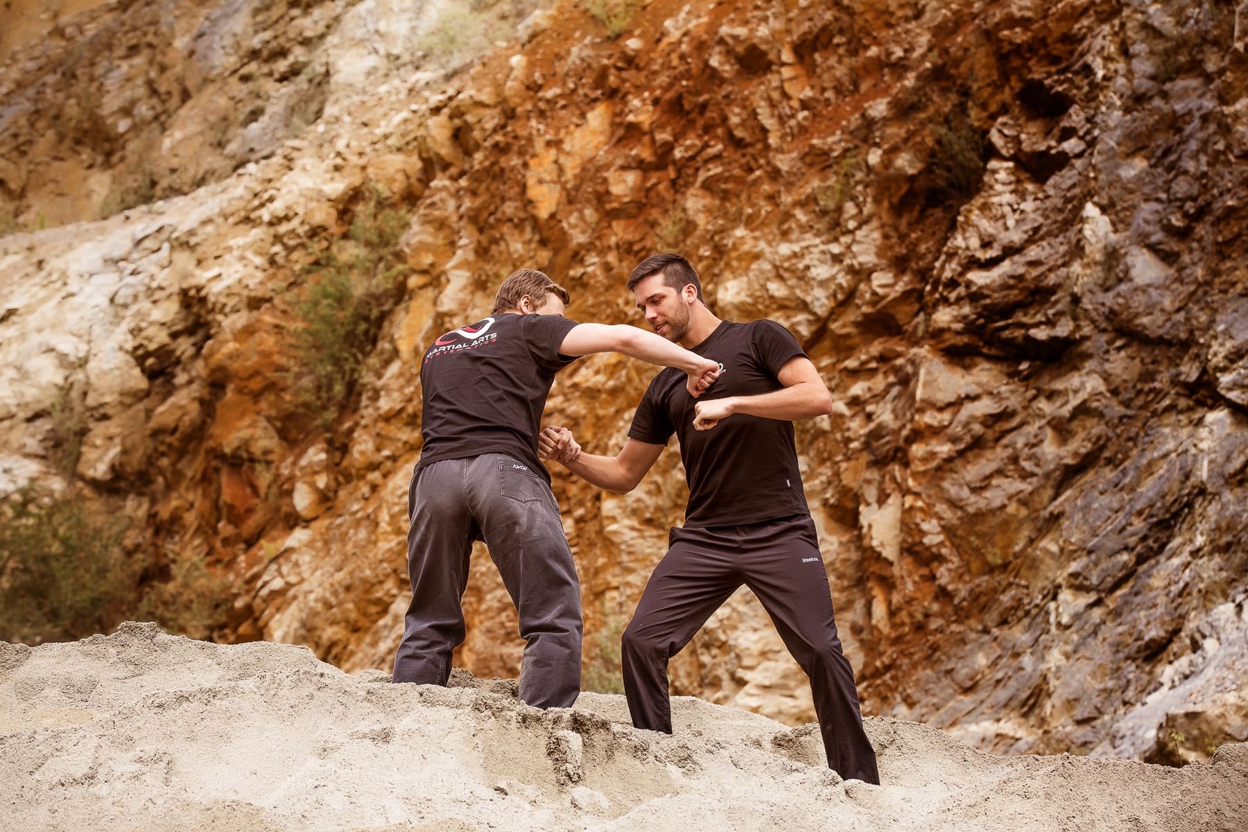 austtechniken als Partnerübung auf felsigem Untergrund im Freien bei einem Fotoshooting für die Akademie für Selbstverteidigung, Kampfkunst und Kampfsport in Graz.