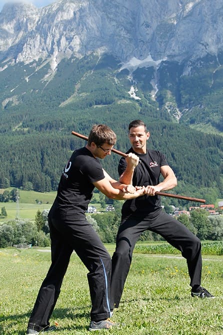 Partnerübung zur Stockabwehr und Entwaffnung beim Waffentraining im Freien der Akademie für Selbstverteidigung, Kampfkünste und Kampfsport in Graz.